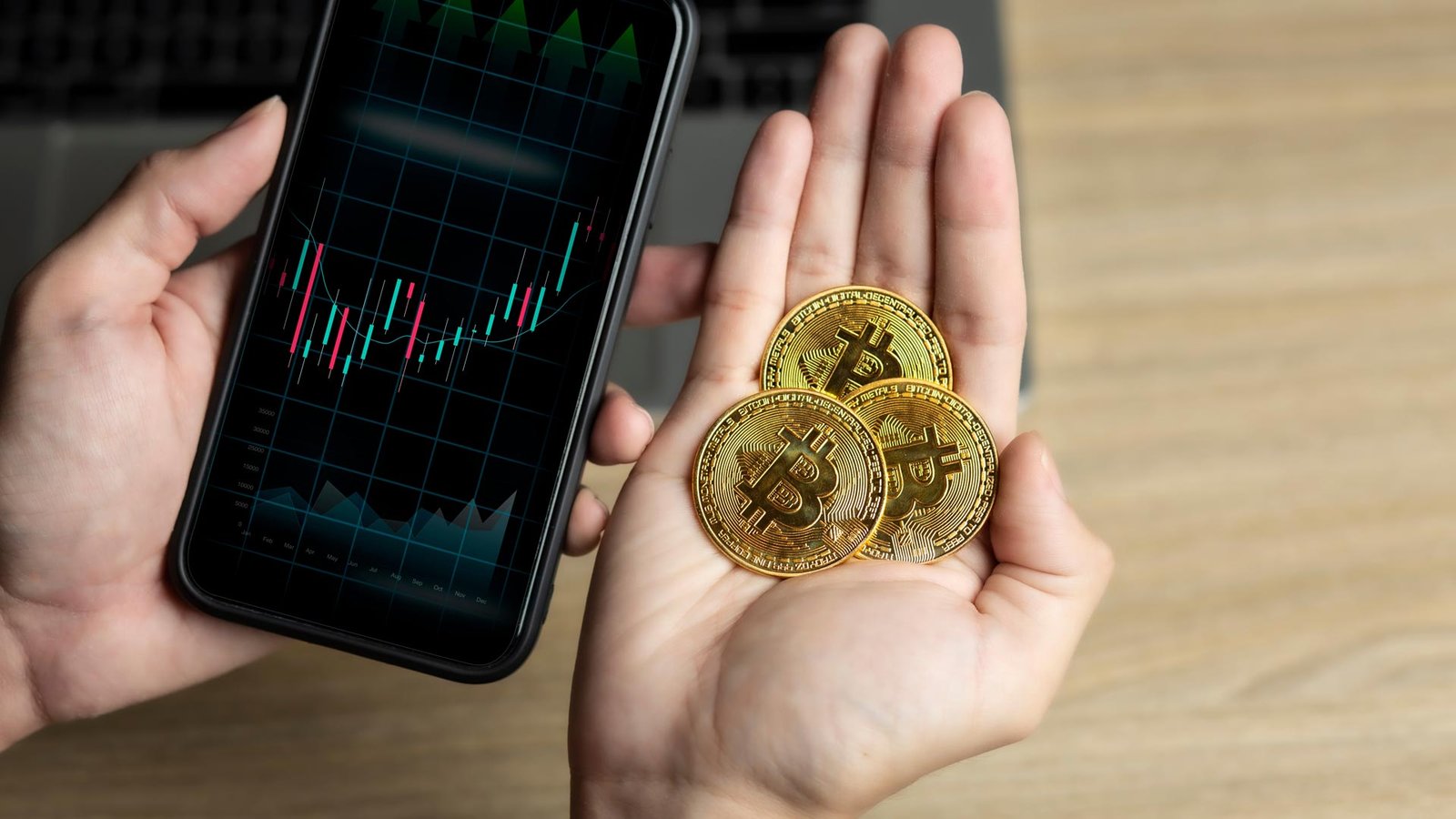 bitcoins in palm while looking at crypto price chart